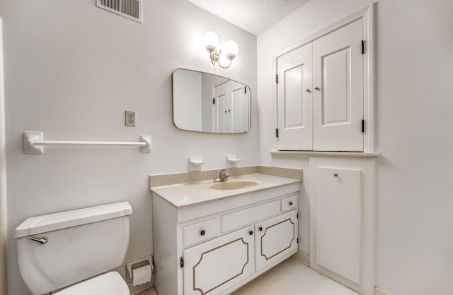 bathroom with toilet, a textured ceiling, and vanity