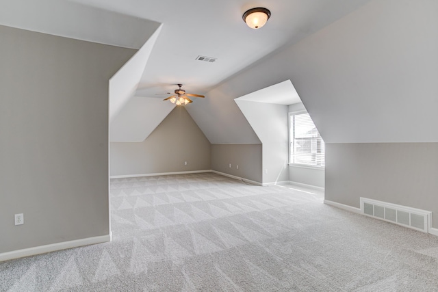 additional living space featuring carpet floors, baseboards, ceiling fan, and vaulted ceiling