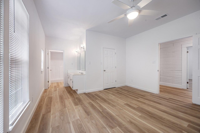 unfurnished bedroom featuring light wood-style floors, baseboards, and ceiling fan