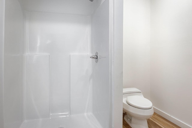 full bathroom featuring toilet, a stall shower, wood finished floors, and baseboards