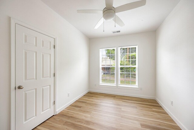 unfurnished room featuring light wood finished floors, baseboards, and a ceiling fan