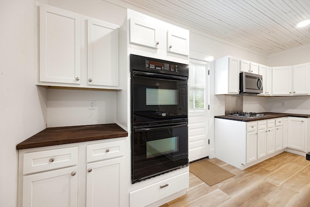 kitchen with stainless steel appliances, light wood-type flooring, white cabinetry, and wooden ceiling