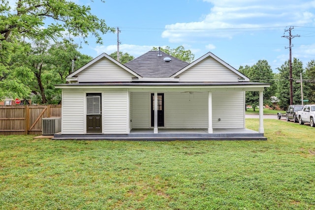 rear view of house featuring central air condition unit and roof with shingles