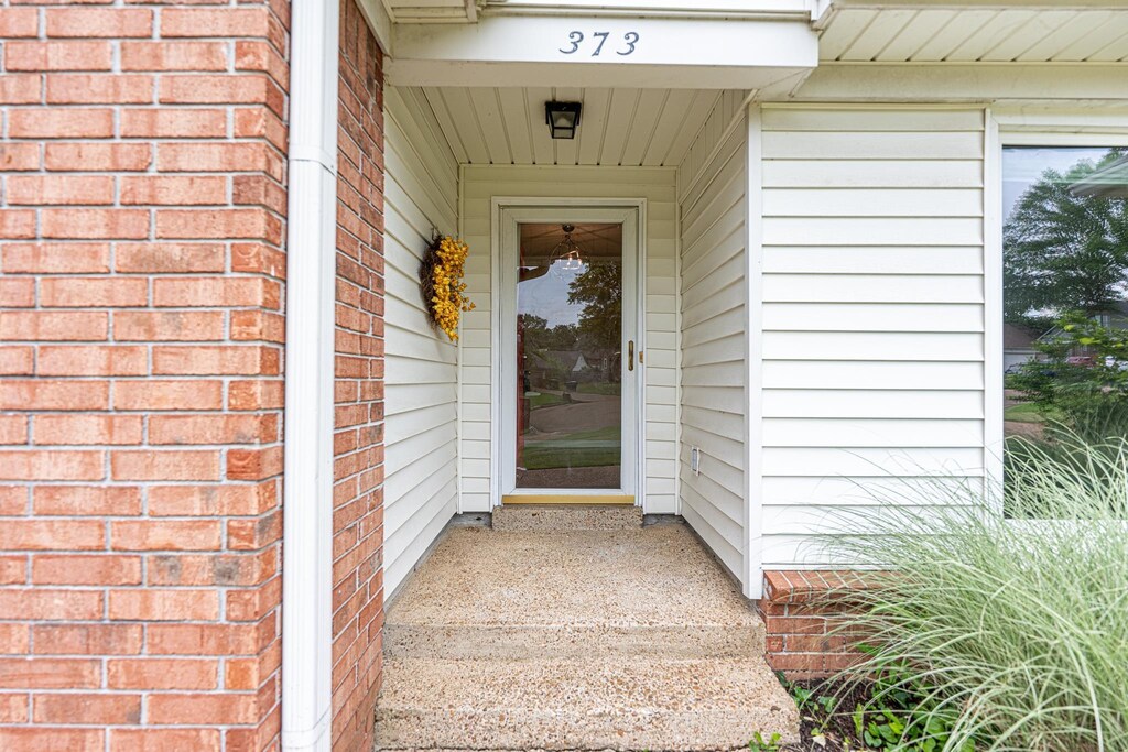 doorway to property with brick siding
