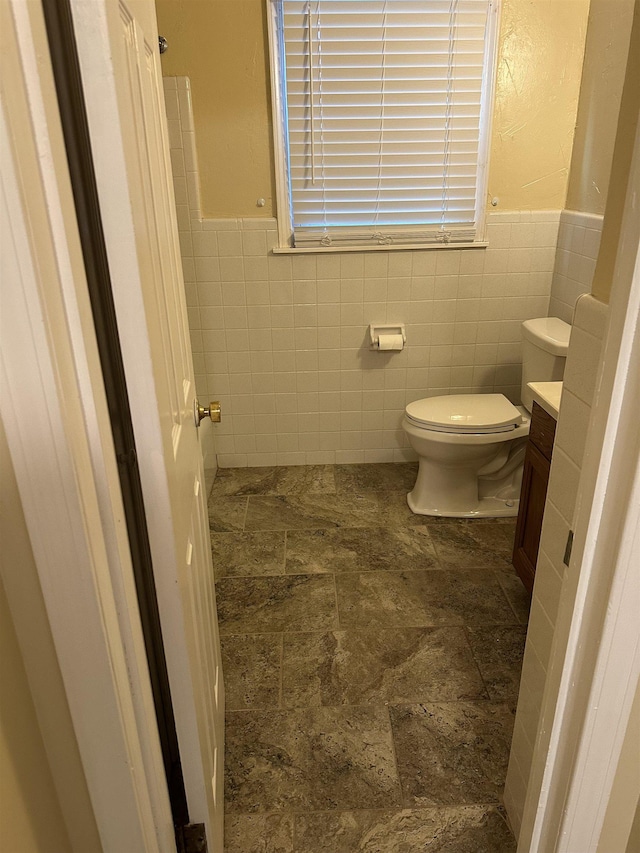 3236 Whitney Rd, Memphis, TN 38128 - bathroom with tile walls, vanity, stone finish flooring, wainscoting, and toilet
