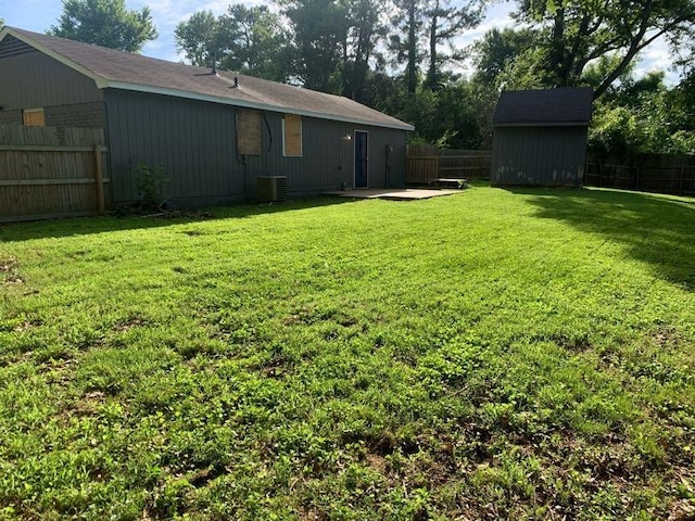 view of yard featuring an outdoor structure, a patio, a shed, and central AC unit