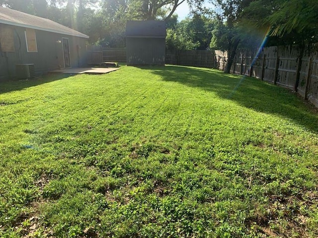 view of yard with an outdoor structure, a patio, a shed, and cooling unit