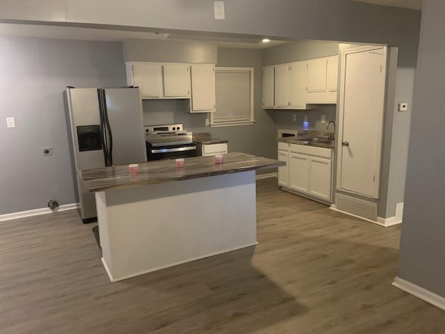 kitchen with stainless steel appliances, white cabinets, and baseboards