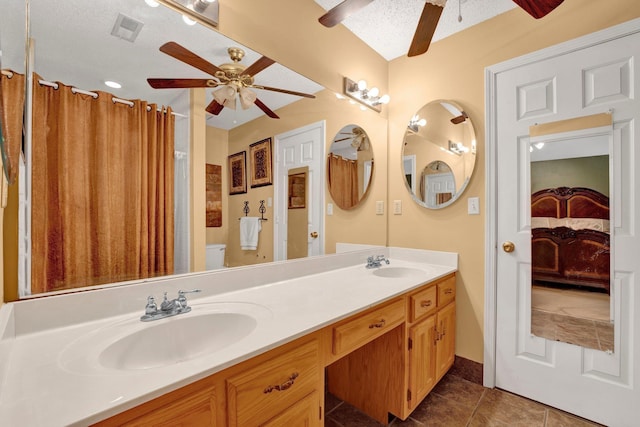 bathroom featuring a ceiling fan, double vanity, tile patterned floors, toilet, and a textured ceiling