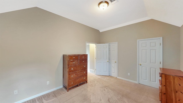 bedroom featuring vaulted ceiling, light carpet, and baseboards