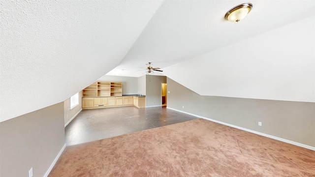 additional living space with baseboards, lofted ceiling, ceiling fan, and carpet