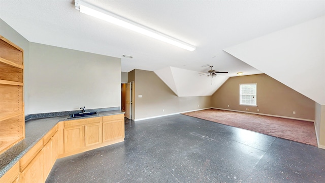 additional living space featuring a sink, baseboards, vaulted ceiling, and ceiling fan