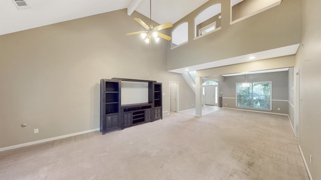 unfurnished living room featuring high vaulted ceiling, ceiling fan, beam ceiling, baseboards, and carpet floors