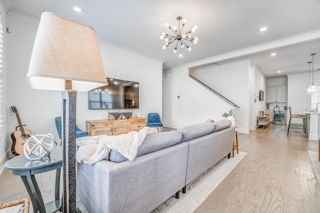 living area with light wood finished floors, a chandelier, ornamental molding, recessed lighting, and baseboards