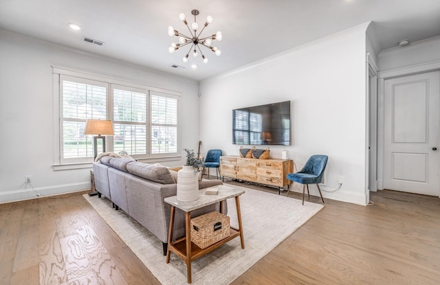 living room with a chandelier, light wood-style floors, baseboards, crown molding, and recessed lighting