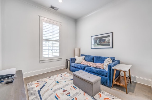 sitting room featuring baseboards, wood finished floors, crown molding, and recessed lighting