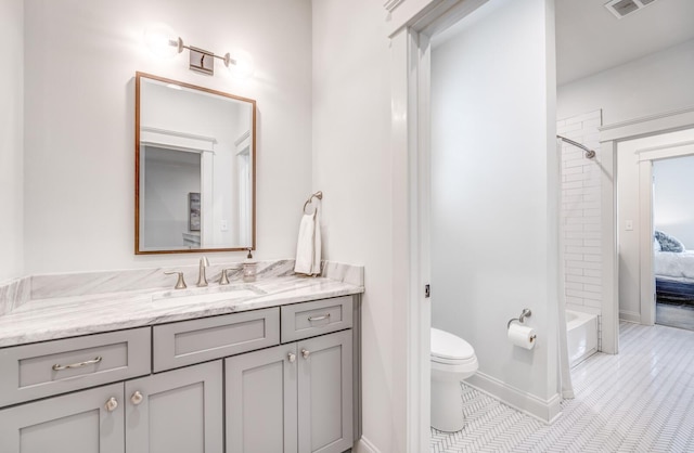 bathroom featuring toilet, vanity, tile patterned flooring,  shower combination, and baseboards