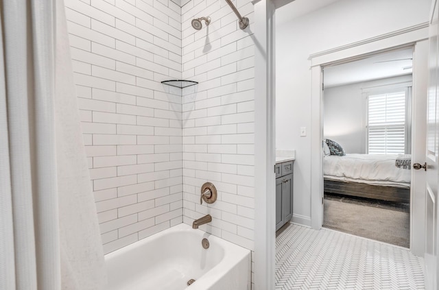ensuite bathroom featuring shower / bath combination with curtain, vanity, and baseboards