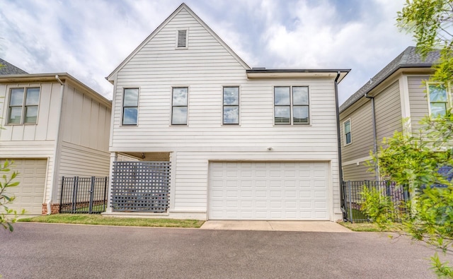 view of front of home with a garage, driveway, and fence