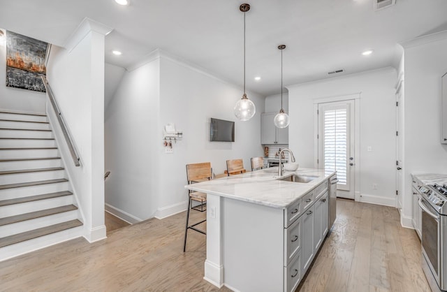kitchen with a sink, appliances with stainless steel finishes, gray cabinets, baseboards, and recessed lighting