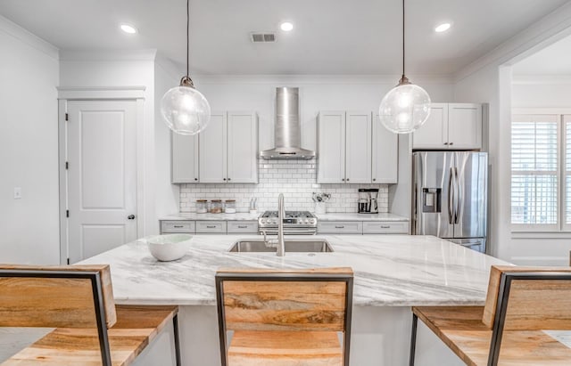 kitchen with wall chimney exhaust hood, stainless steel fridge with ice dispenser, a breakfast bar area, decorative backsplash, and ornamental molding