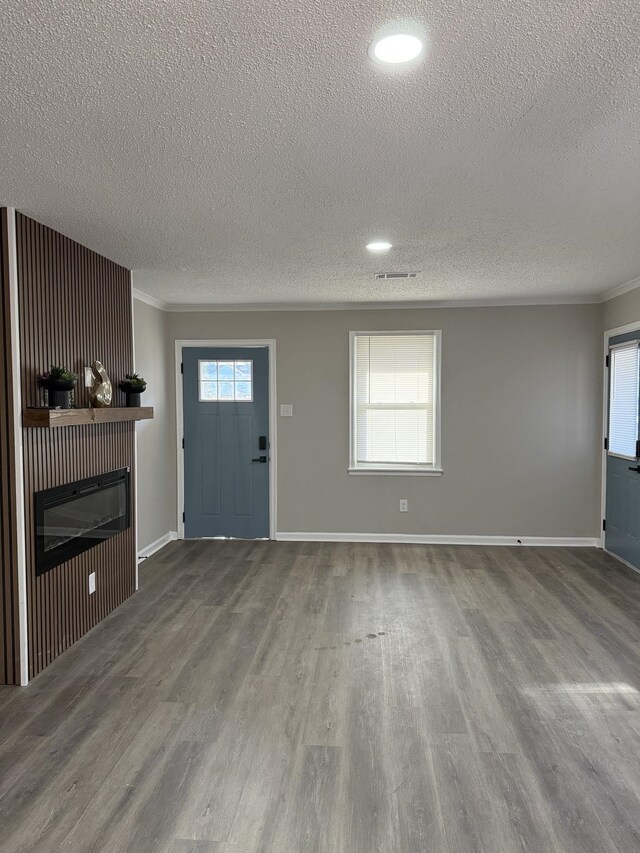 1340 S Perkins Rd, Memphis, TN 38117 - unfurnished living room featuring a textured ceiling, a glass covered fireplace, wood finished floors, crown molding, and baseboards