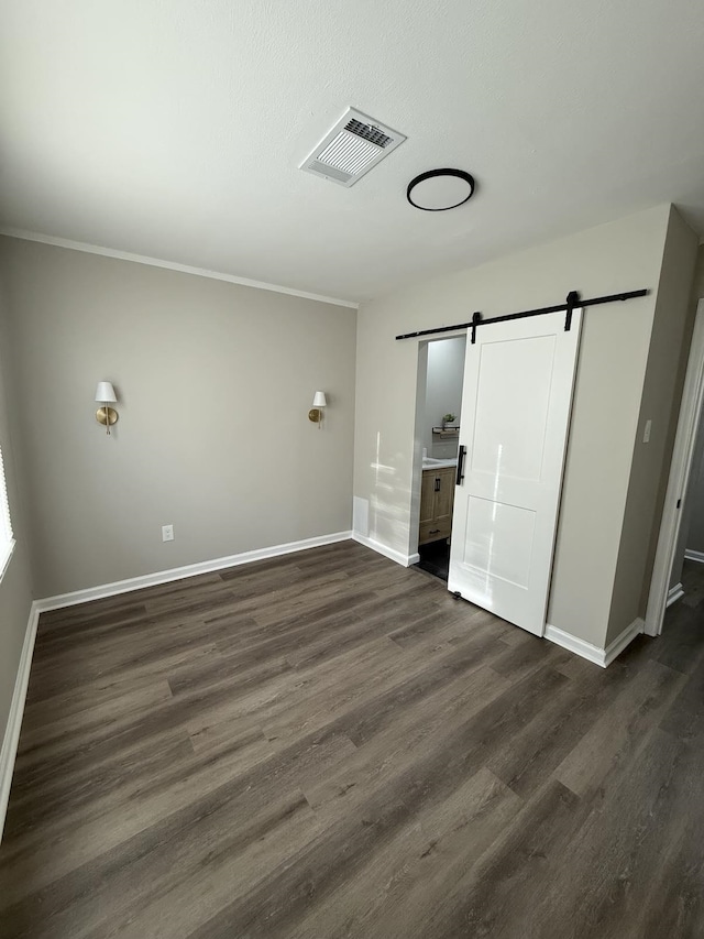 1340 S Perkins Rd, Memphis, TN 38117 - unfurnished bedroom with a barn door, dark wood finished floors, baseboards, and ornamental molding