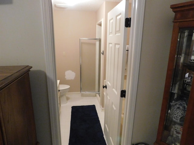 full bath featuring a stall shower, toilet, vanity, and baseboards