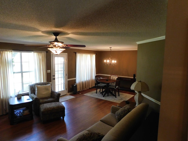 living room with a chandelier, healthy amount of natural light, wood finished floors, a textured ceiling, and crown molding