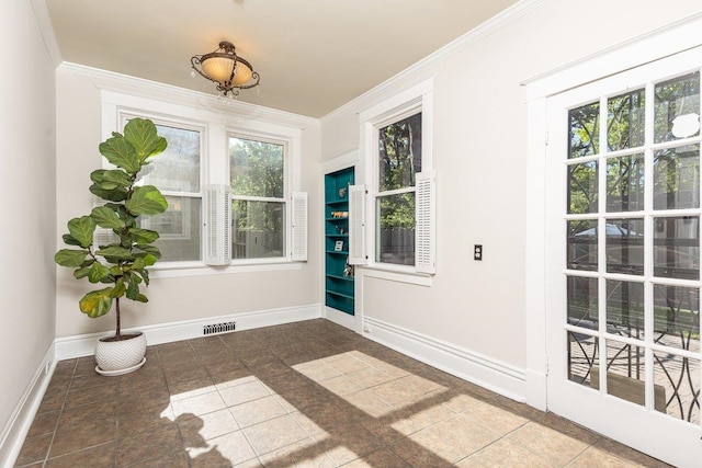 doorway featuring healthy amount of natural light, ornamental molding, and baseboards