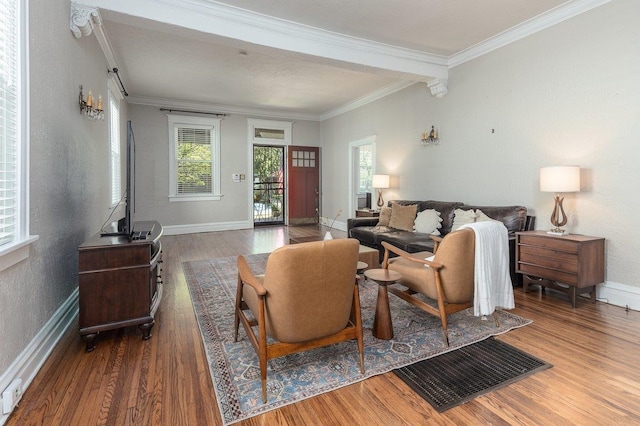 living room with wood finished floors, ornamental molding, and baseboards