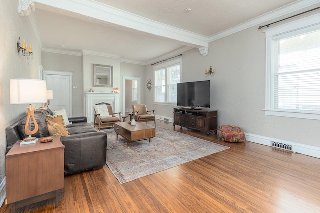 living room featuring wood finished floors, crown molding, a fireplace, baseboards, and beam ceiling