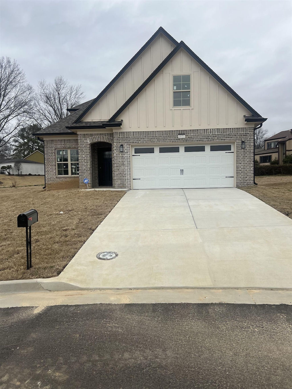 2831 Epping Crest Cv, Memphis, TN 38128 - view of front of house featuring brick siding, concrete driveway, board and batten siding, and an attached garage
