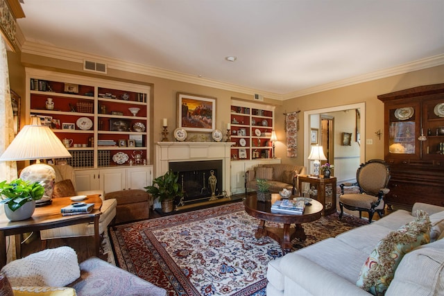 living area with crown molding, built in shelves, and a fireplace with raised hearth