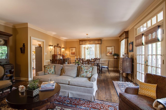 living area with hardwood / wood-style floors, baseboards, crown molding, and a chandelier