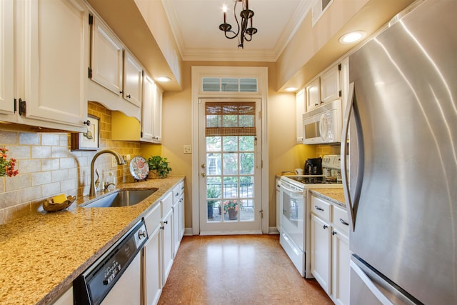 kitchen featuring white appliances, a sink, crown molding, white cabinets, and tasteful backsplash
