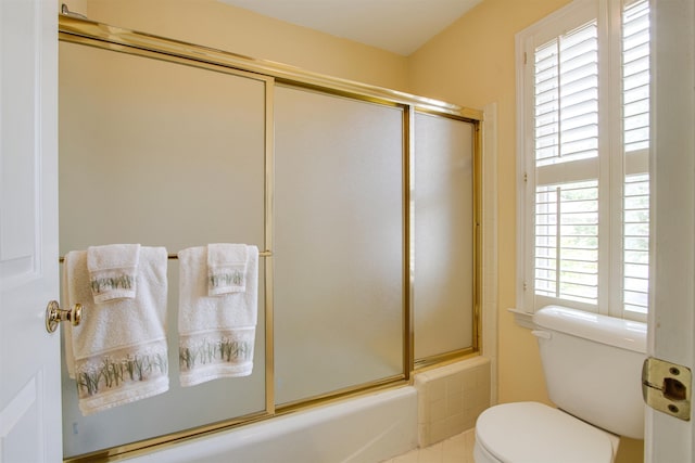 bathroom with toilet and combined bath / shower with glass door