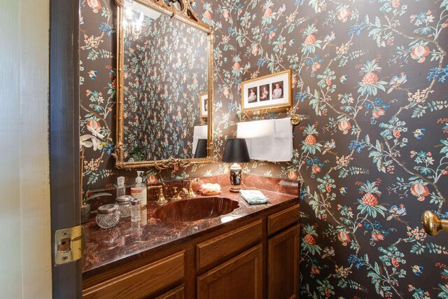 bathroom with vanity and wallpapered walls