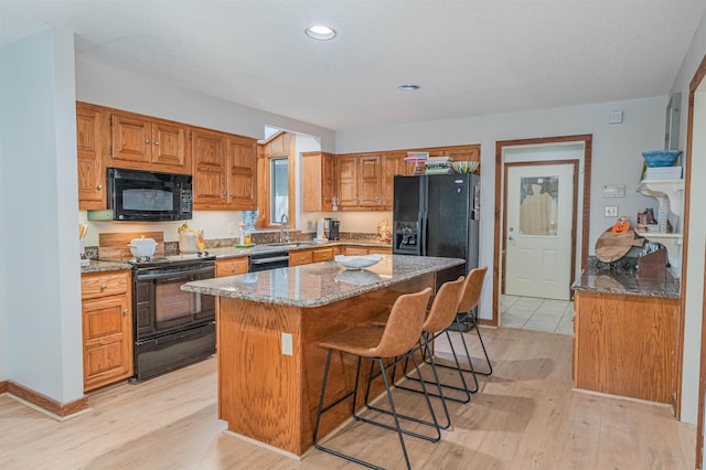 150 Island View Dr, Counce, TN 38326 - kitchen featuring black appliances, a sink, light stone counters, light wood-style flooring, and recessed lighting