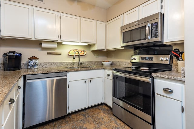 6932 Midhurst Rd Unit 6932, Memphis, TN 38119 - kitchen featuring appliances with stainless steel finishes, white cabinetry, light stone countertops, and stone finish flooring