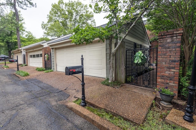 6932 Midhurst Rd Unit 6932, Memphis, TN 38119 - view of home's exterior with a garage, a gate, and brick siding