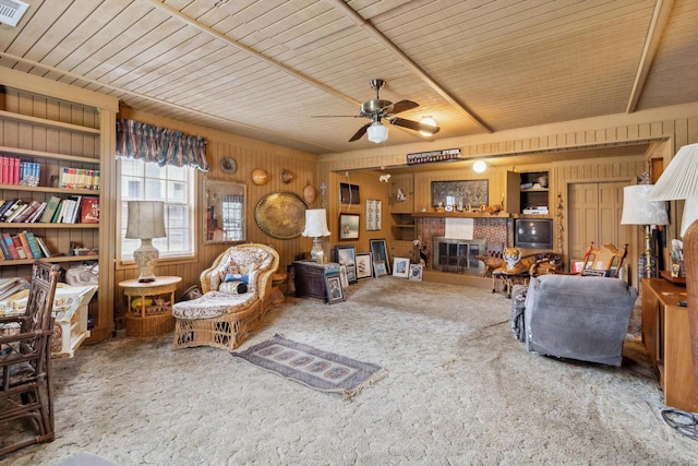 4948 Roane Rd, Memphis, TN 38117 - carpeted living area featuring wood walls, a glass covered fireplace, ceiling fan, and wood ceiling