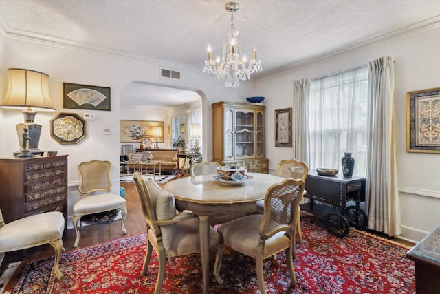 4948 Roane Rd, Memphis, TN 38117 - dining area featuring arched walkways, ornamental molding, wood finished floors, a chandelier, and baseboards