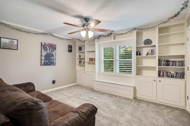 living room with ceiling fan, light colored carpet, a textured ceiling, and baseboards