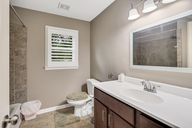 full bath with tiled shower, baseboards, vanity, and toilet