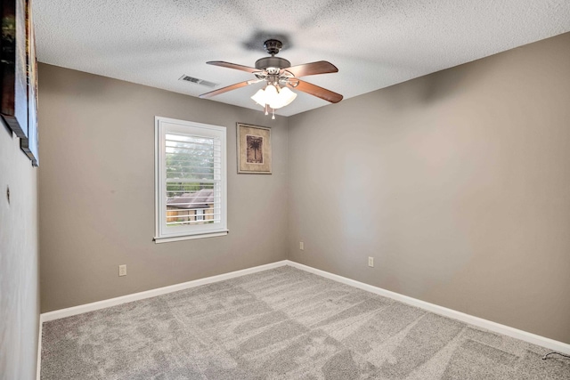 spare room with ceiling fan, carpet, a textured ceiling, and baseboards