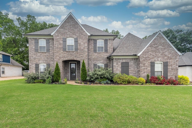 view of front of property featuring brick siding, a front lawn, and a shingled roof