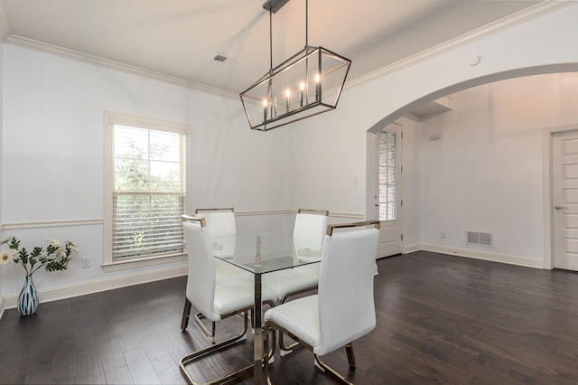 dining space with arched walkways, dark wood-type flooring, crown molding, baseboards, and a chandelier