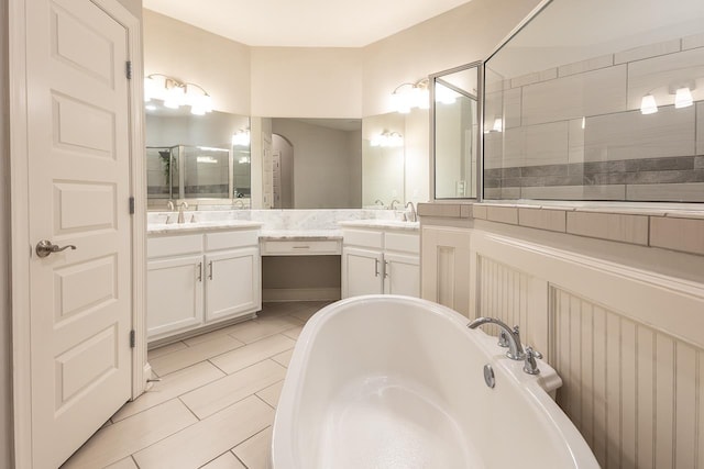 full bath with a freestanding bath, tile patterned flooring, and vanity