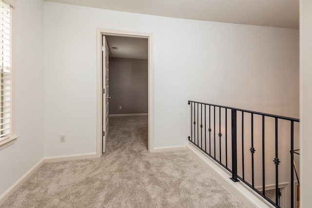 hallway with carpet floors and baseboards